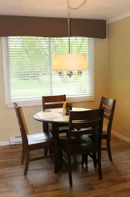 a dining room with a table and chairs and a lamp at Studiotel Bromont in Bromont