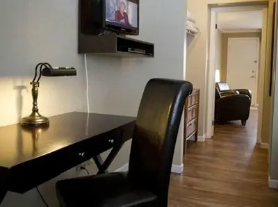 a desk with a chair and a television in a room at Studiotel Bromont in Bromont