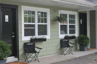 two black chairs sitting outside of a house at Studiotel Bromont in Bromont