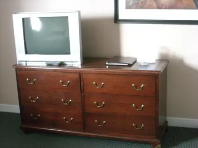 a dresser with a television on top of it at Grand Motel Saint-Hubert in Longueuil