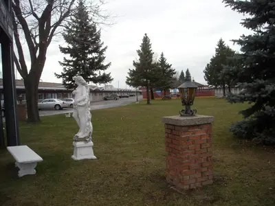 a statue of a woman standing next to a brick pillar at Grand Motel Saint-Hubert in Longueuil