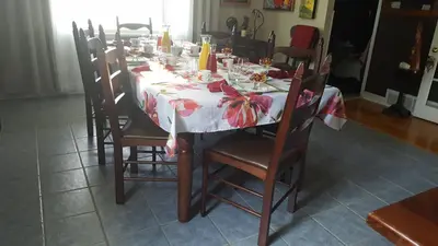 a dining room table with a red and white table cloth at Atelier Galerie Anne Drouin Peinture & Pension in Sainte-Julie