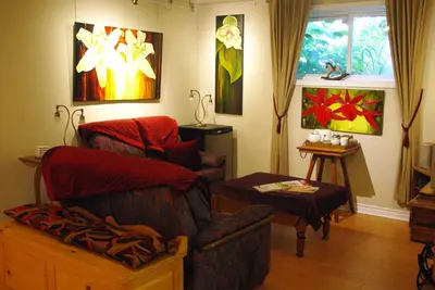 a living room with two chairs and a table at Atelier Galerie Anne Drouin Peinture & Pension in Sainte-Julie