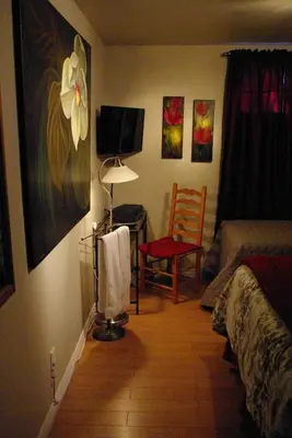 a room with a bedroom with a bed and a chair at Atelier Galerie Anne Drouin Peinture & Pension in Sainte-Julie