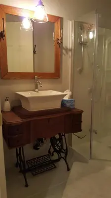 a bathroom with a sink and a mirror and a shower at Atelier Galerie Anne Drouin Peinture & Pension in Sainte-Julie