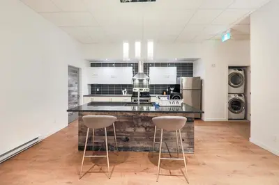 a kitchen with a counter and two bar stools at HoMa Homestay Hotel by Olympic Stadium Montreal Auberge-Hostel in Montréal