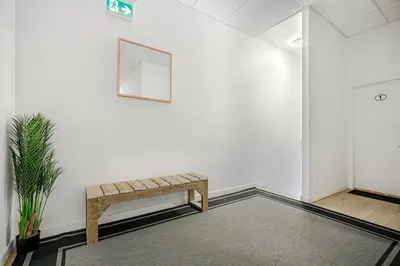 a bench in an empty room with a picture on the wall at HoMa Homestay Hotel by Olympic Stadium Montreal Auberge-Hostel in Montréal