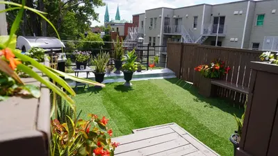 a small backyard with grass and plants on a balcony at HoMa Homestay Hotel by Olympic Stadium Montreal Auberge-Hostel in Montréal