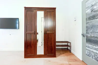 a wooden door in a room with a mirror at HoMa Homestay Hotel by Olympic Stadium Montreal Auberge-Hostel in Montréal