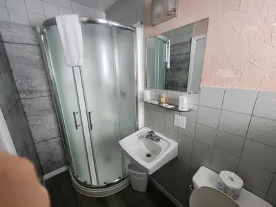 a bathroom with a shower and a sink at Motel Le Victo in Victoriaville