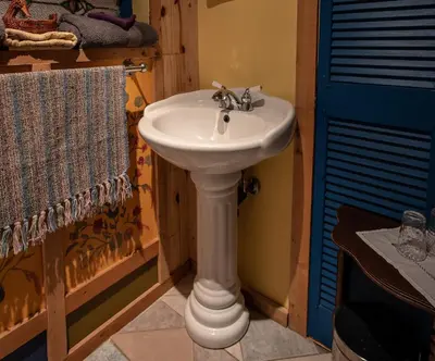 a bathroom with a white sink and a blue door at Auberge Restaurant La Mara in Saint-Joseph-de-Ham-Sud