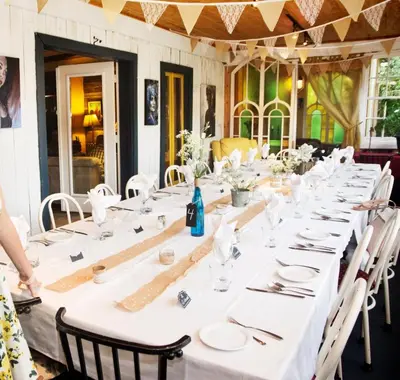 a long table with white tablecloths and napkins at Auberge Restaurant La Mara in Saint-Joseph-de-Ham-Sud