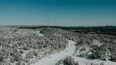 a snow covered hill with a road and trees at Comfort Inn in Saint-Georges