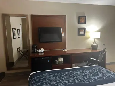 a hotel room with a bed and a flat screen tv at Comfort Inn in Saint-Georges