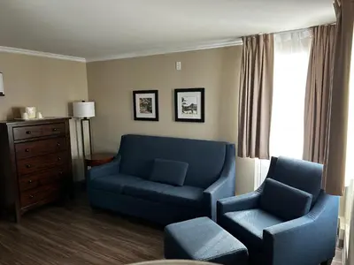 a living room with a blue couch and a chair at Comfort Inn in Saint-Georges
