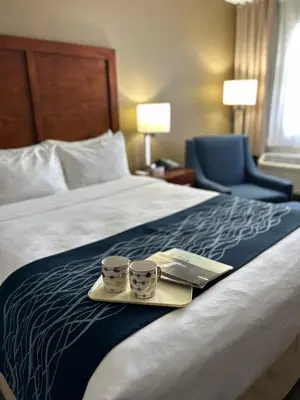 a hotel room with two cups on a bed at Comfort Inn in Saint-Georges