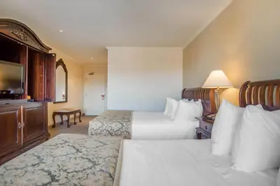 a hotel room with two beds and a television at St Christophe Hotel & Spa, an Ascend Collection Hotel in Granby