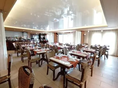 a dining room with tables and chairs in a restaurant at St Christophe Hotel & Spa, an Ascend Collection Hotel in Granby