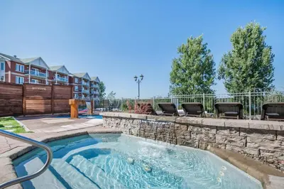 a swimming pool with chairs and a fence at St Christophe Hotel & Spa, an Ascend Collection Hotel in Granby