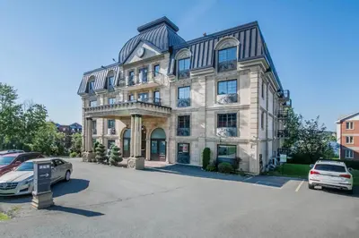 a large building with cars parked in a parking lot at St Christophe Hotel & Spa, an Ascend Collection Hotel in Granby