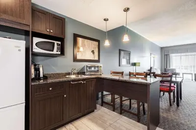 a kitchen with a counter top and a dining room at Quality Inn & Suites in Victoriaville