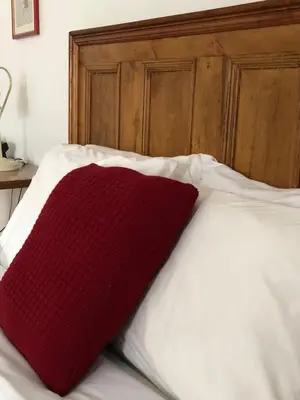 a red pillow sitting on top of a bed at AUBERGE Knowlton in Lac-Brome