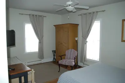 a bedroom with a bed and a ceiling fan at AUBERGE Knowlton in Lac-Brome