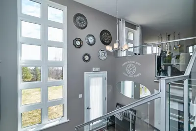 a room with clocks on the wall and a staircase at Auberge Aux Deux Pères in Magog-Orford