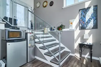 a metal staircase in a kitchen with a microwave at Auberge Aux Deux Pères in Magog-Orford