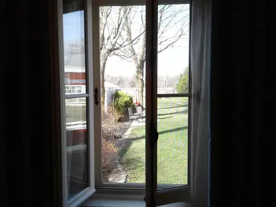 an open window with a view of a yard at Le Gîte Du Coteau in Lyster