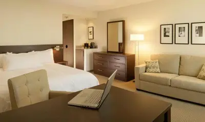 a hotel room with a bed and a laptop on a desk at le Georgesville in Saint-Georges
