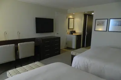 a hotel room with two beds and a flat screen tv at le Georgesville in Saint-Georges