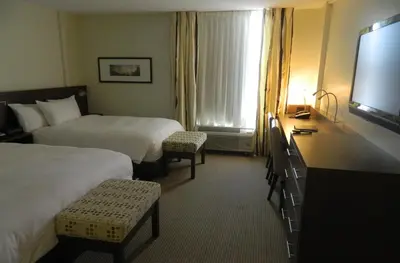 a hotel room with two beds and a flat screen tv at le Georgesville in Saint-Georges