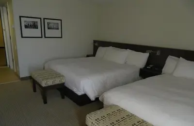 a hotel room with two beds and a stool at le Georgesville in Saint-Georges