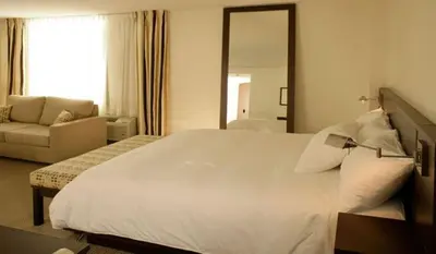 a bedroom with a large white bed and a couch at le Georgesville in Saint-Georges