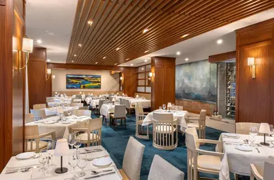 a dining room with white tables and chairs at le Georgesville in Saint-Georges