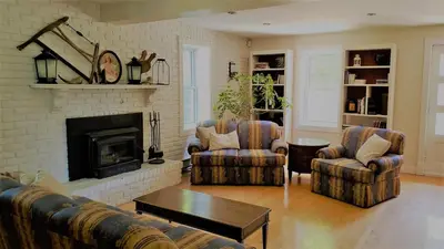 a living room with two chairs and a fireplace at Auberge du Vignoble Bromont in Bromont