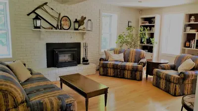a living room with two couches and a fireplace at Auberge du Vignoble Bromont in Bromont