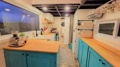 a kitchen with blue cabinets and a large window at Auberge du Vignoble Bromont in Bromont