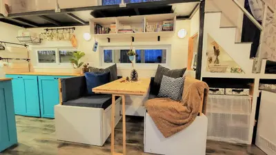 a kitchen with a table and chairs in a tiny house at Auberge du Vignoble Bromont in Bromont