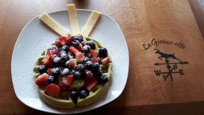 a waffle with fruit on a plate on a table at Domaine de La Giroux-ette in La Patrie