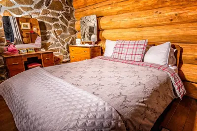 a bedroom with a bed and a stone wall at Domaine de La Giroux-ette in La Patrie