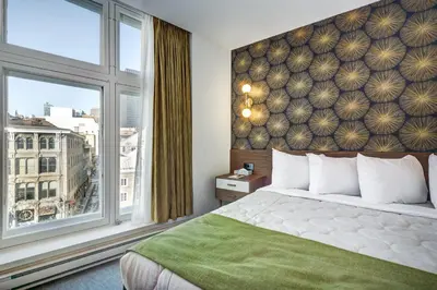 a hotel room with a bed and a large window at Hôtel Uville Montréal in Montréal