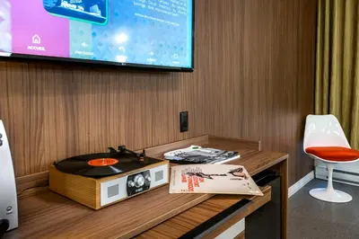 a room with a table with a cd and a tv at Hôtel Uville Montréal in Montréal