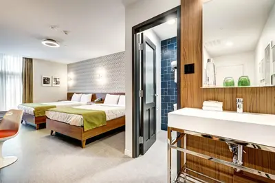 a hotel room with two beds and a sink at Hôtel Uville Montréal in Montréal