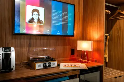 a room with a tv and a table with a lamp at Hôtel Uville Montréal in Montréal
