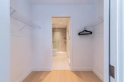 a hallway with white walls and a hallway leading to a bathroom at Le Se7t Penthouses in Montréal