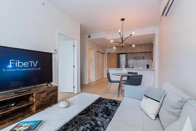 a living room with a couch and a tv at Le Se7t Penthouses in Montréal