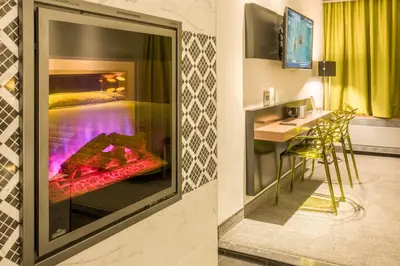 a hotel room with a fireplace and a bedroom at Le Chabrol Hotel & Suites in Montréal