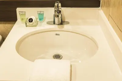 a white bathroom sink with a towel on it at Le Chabrol Hotel & Suites in Montréal
